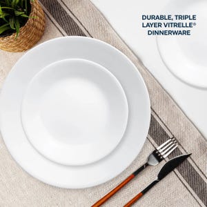 White triple-layer Vitrelle dinnerware set comprising of large and small round plates with a fork and knife on a striped napkin.