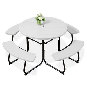 Round folding picnic table set with a white tabletop, integrated with three curved benches and a central umbrella hole. Decorated with a small flower arrangement.