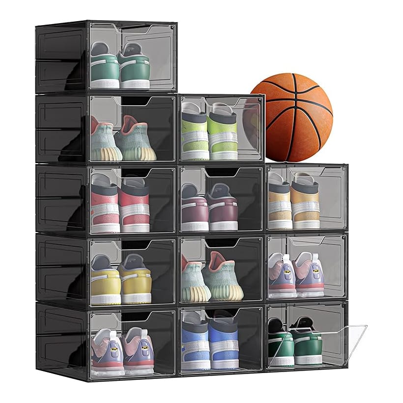 12pk stackable shoe organizers with transparent front doors hold various shoes, visible in a grid. They form a compact, tidy storage solution. A basketball is placed on top, suggesting versatility in storage uses.