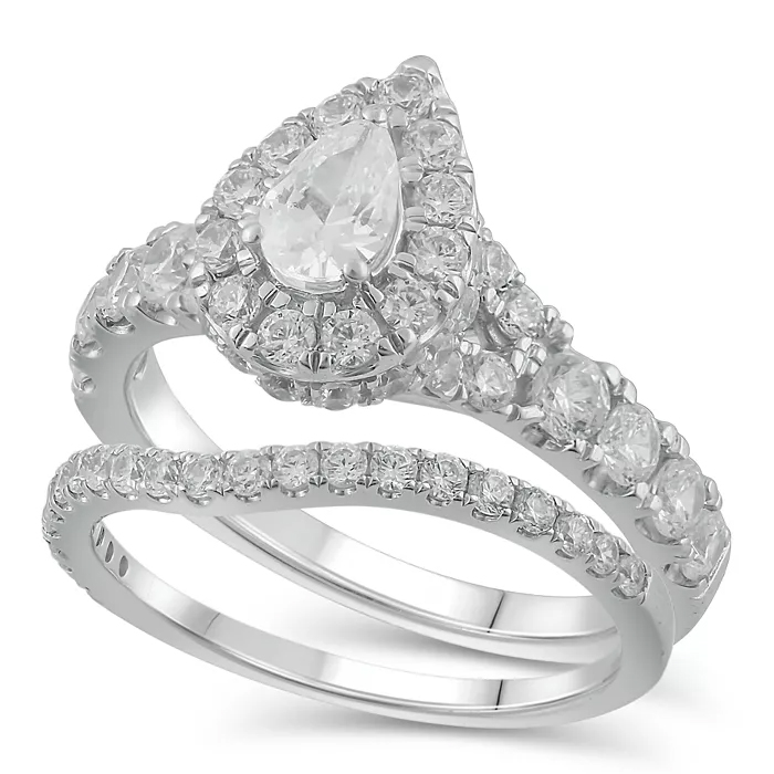 A bridal set featuring a pear-cut diamond ring with a halo of smaller diamonds, accompanied by a diamond-studded matching band, all set in white gold.
