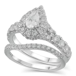 A bridal set featuring a pear-cut diamond ring with a halo of smaller diamonds, accompanied by a diamond-studded matching band, all set in white gold.