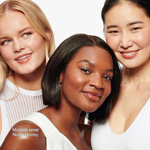 Three models showcase a makeup shade called \“Nude Honey,\“ wearing white tops against a neutral background. The focus is on the diverse application of the shade.