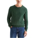 A man is wearing a green cable knit sweater paired with blue jeans. The sweater features a round neckline and ribbed cuffs and hem.