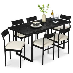 A black dining set featuring a rectangular table and six chairs with cream cushioned seats. The table is decorated with a vase of greenery, a bottle of wine, wine glasses, and stacked plates.