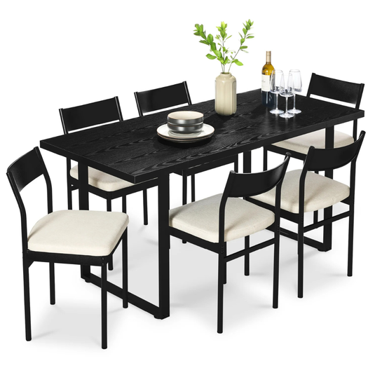 A black dining set featuring a rectangular table and six chairs with cream cushioned seats. The table is decorated with a vase of greenery, a bottle of wine, wine glasses, and stacked plates.