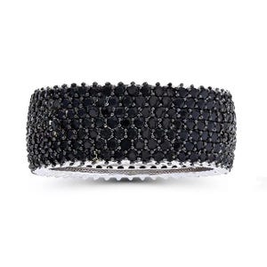 A wide bangle encrusted with multiple rows of small, round black gemstones, set in a silver-tone metal.