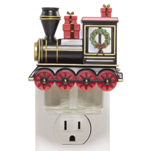 A festive train-themed wall plug-in fragrance diffuser decorated with red-rimmed wheels, a wreath, and gift boxes, plugged into an electrical outlet.