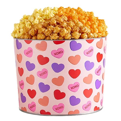 Three different types of popcorn in a pink heart-printed tin.