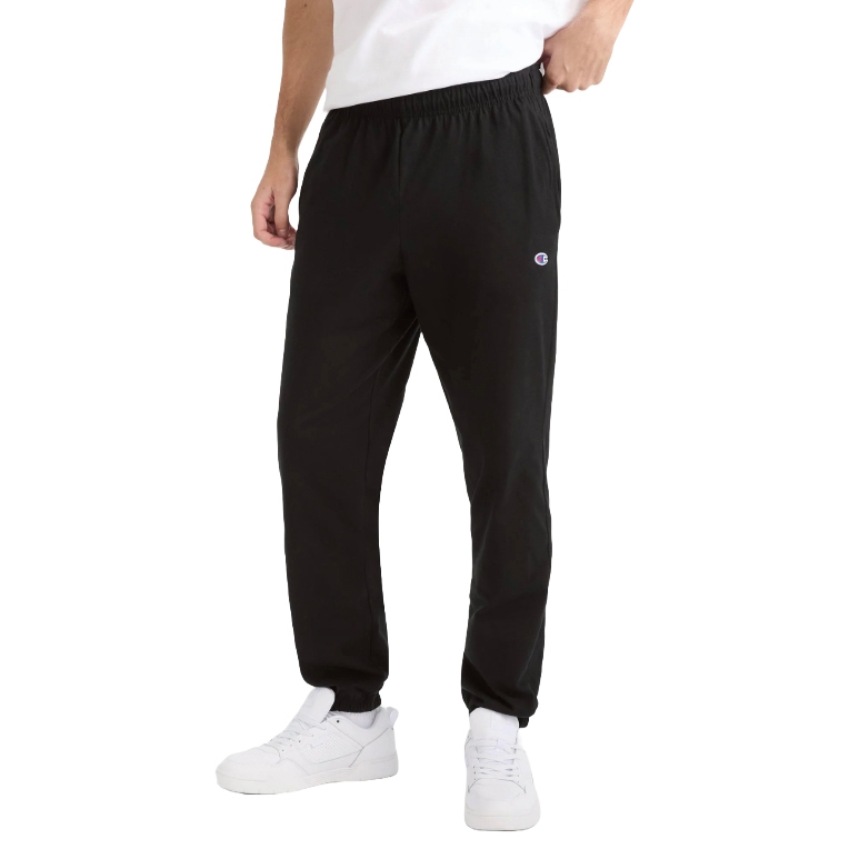 Black jogger pants with an elastic waistband paired with white sneakers and a white T-shirt; a small logo is visible on the pants.