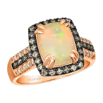 A rose gold ring by Le Vian featuring a cushion-cut opal center stone, surrounded by rows of black and white diamonds, arranged in a split shank design.