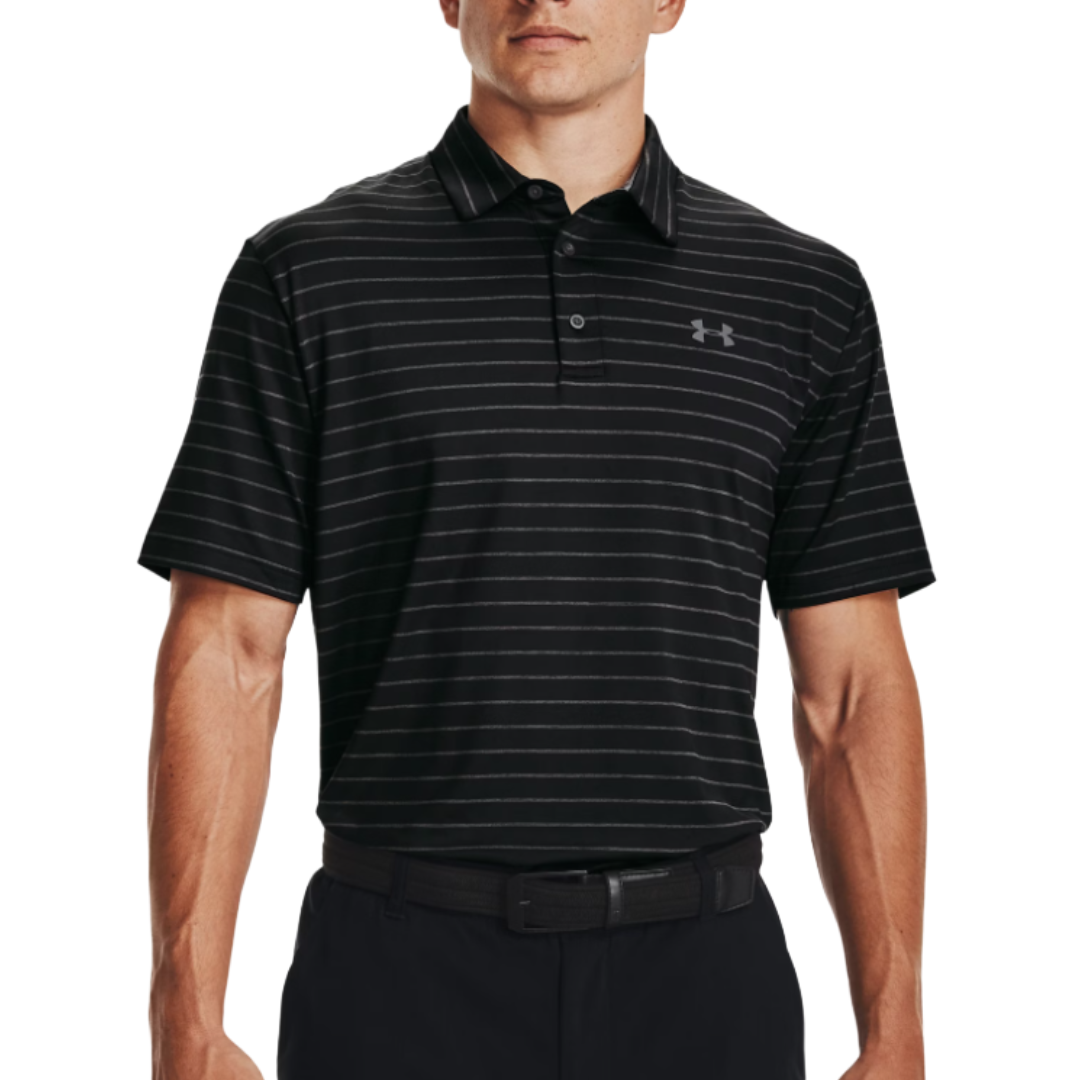 A man is wearing a black Under Armour striped polo shirt and black pants. The polo features subtle horizontal stripes and the Under Armour logo on the chest.