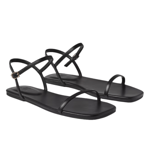 Black strappy flat sandals with thin straps, including an adjustable ankle strap and toe loop, featuring a minimalist design.