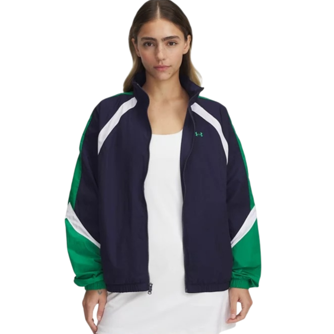 A woman is wearing a navy and green zip-up jacket with white accents from Under Armour, over a white dress.