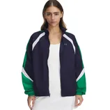 A woman is wearing a navy and green zip-up jacket with white accents from Under Armour, over a white dress.