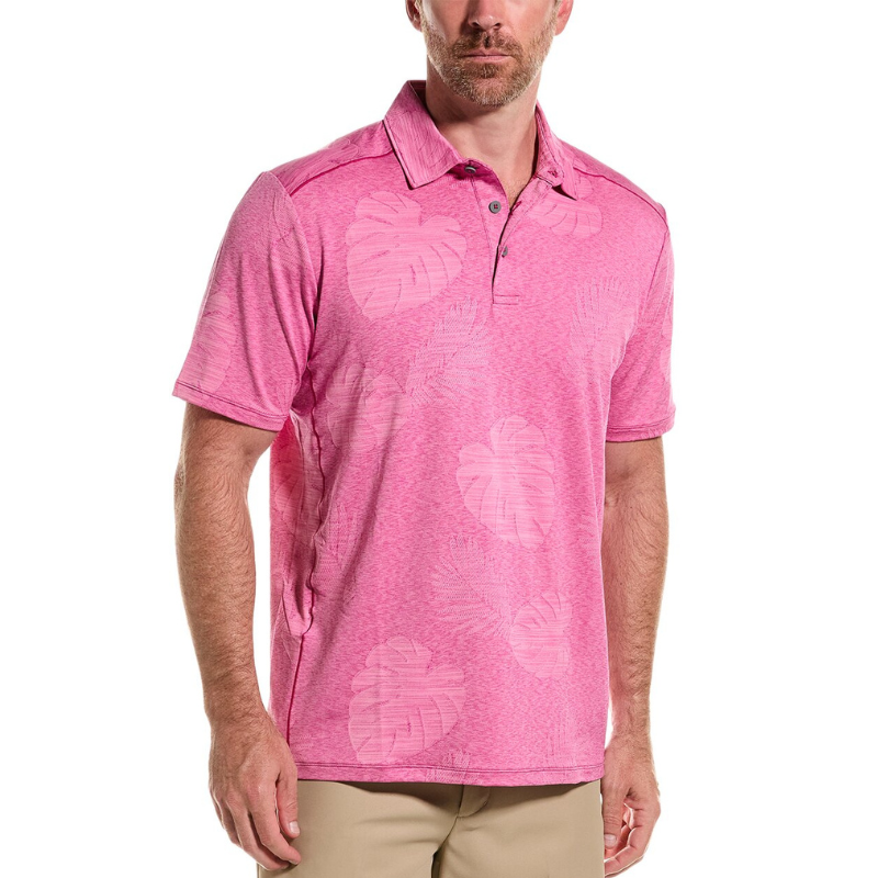 A pink polo shirt featuring a subtle leaf pattern, short sleeves, a collar, and a three-button placket, paired with light beige pants.