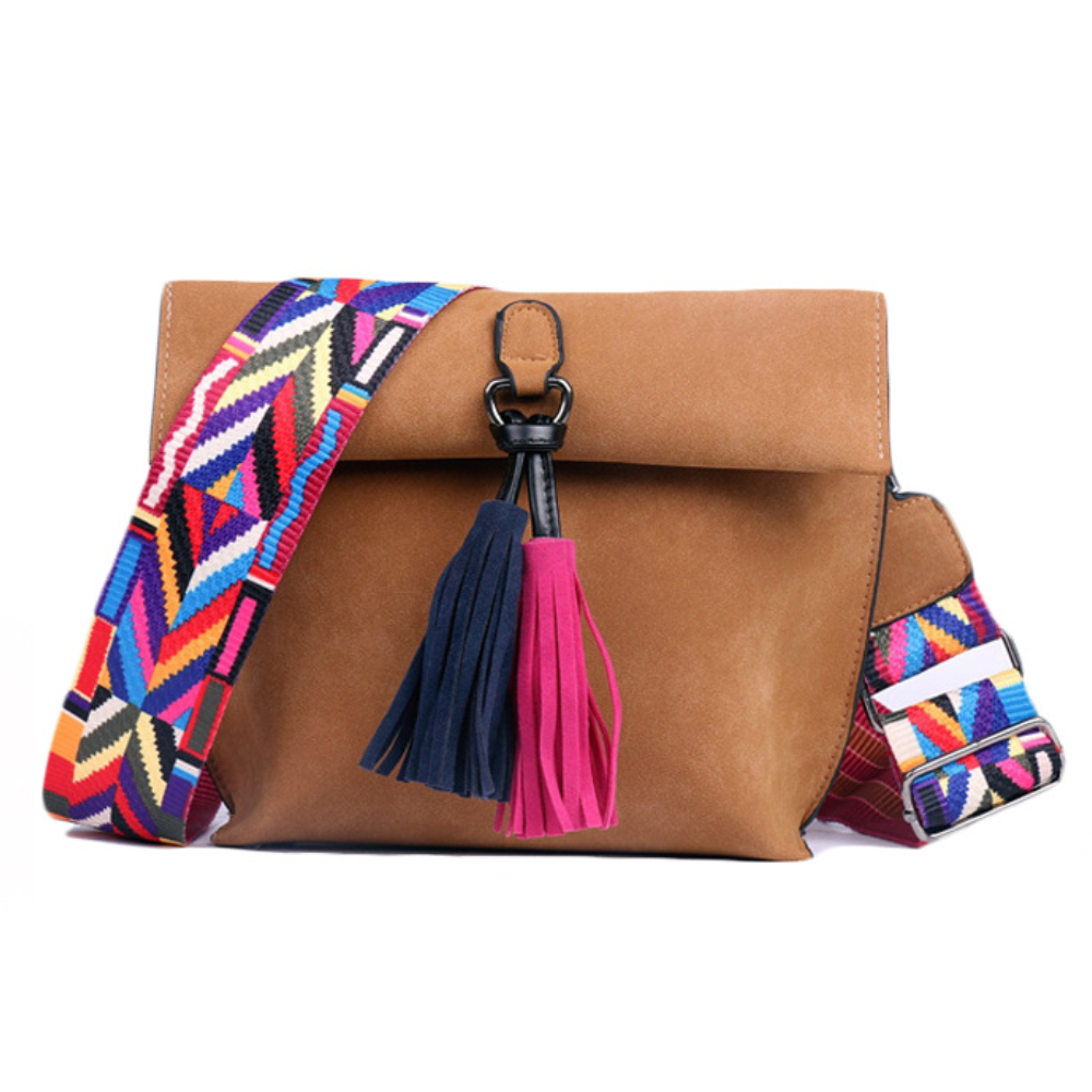 A brown shoulder bag with a colorful, geometric-patterned strap and tassels in blue and pink.