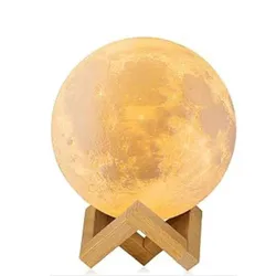 A moon lamp with a realistic lunar surface design on a wooden stand, emitting a warm glow.