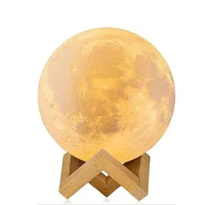 A moon lamp with a realistic lunar surface design on a wooden stand, emitting a warm glow.
