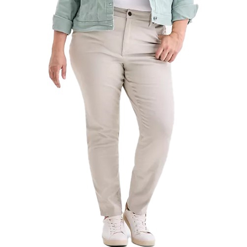 A person is wearing beige pants paired with white sneakers and a light green jacket.