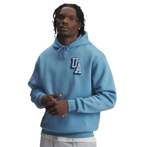 A person wearing a light blue hoodie with \“UA\“ on the chest, featuring a drawstring hood and a relaxed fit. The outfit is complemented with light-colored shorts.