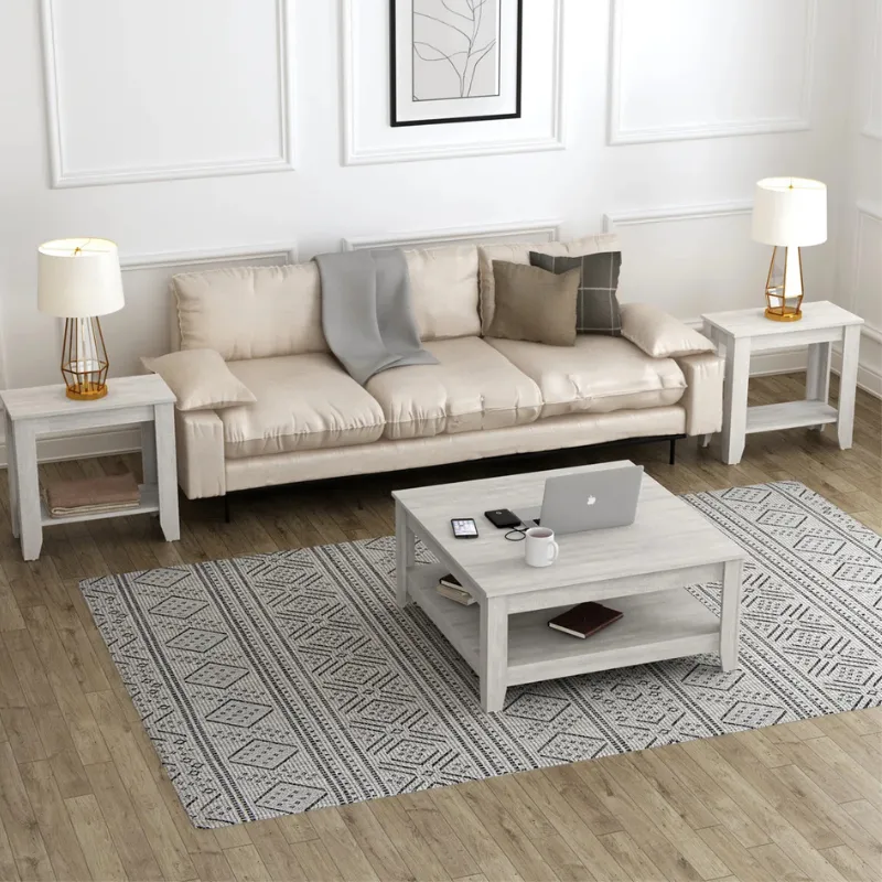 Living room setup with a beige sofa, two side tables with lamps, a central coffee table holding a laptop, phone, and cup, and a patterned rug on wooden flooring.