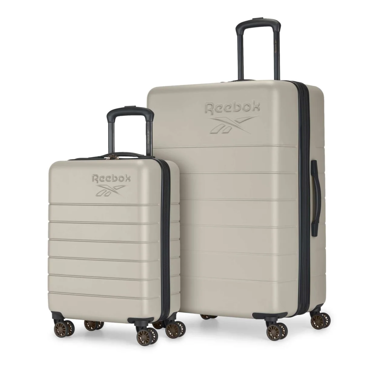 Two beige Reebok suitcases, one smaller and one larger, each with a logo and four wheels.