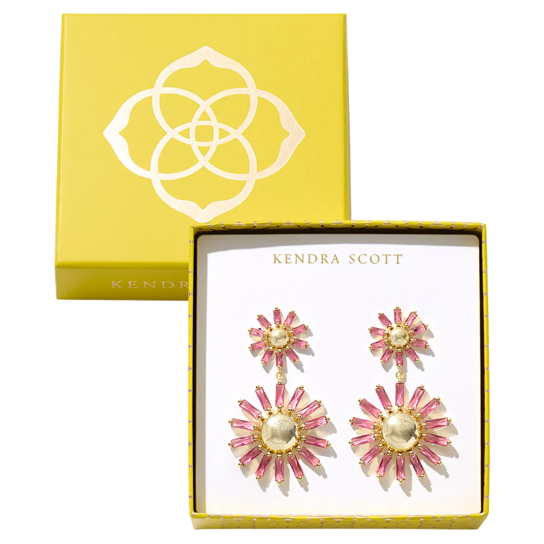 A pair of Kendra Scott earrings, featuring a vibrant design with pink and gold accents, presented in a yellow box with the brand's logo.