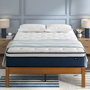 A neatly made bed with a tufted mattress and a light blanket is placed on a wooden frame. The scene includes a nightstand with a lamp on each side, with one having a cup and the other a vase of flowers.