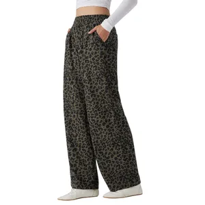 Wide-leg trousers with a black leopard print pattern, elastic waistband, and side pockets, paired with a white long-sleeve top and white shoes.