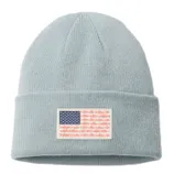 A light gray knit beanie featuring a patch designed like an American flag, with fish shapes where the stripes would be.
