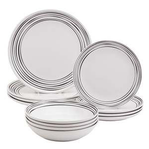 A set of white dinnerware featuring plates and bowls with black concentric circle designs.