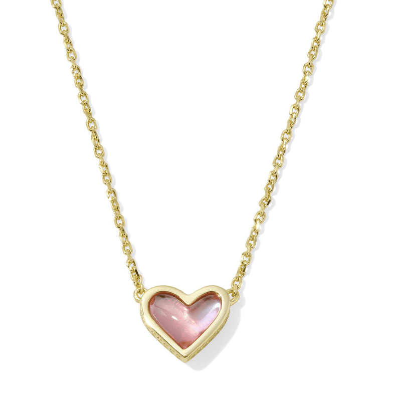 A gold chain necklace featuring a heart-shaped pendant with a pink stone set in a gold frame.