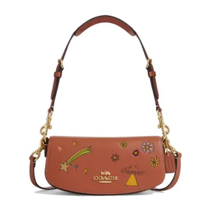 A brown Coach shoulder bag with a detachable strap, adorned with star, flower, and comet illustrations.