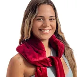 A person wearing a plush red scarf draped over their shoulders. The scarf is soft-textured, adding a pop of color against a light outfit.