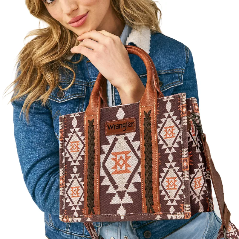 Wrangler Cross Body Mini Tote features a brown and orange geometric pattern with leather accents and handles. The bag has a leather strap and a prominent \“Wrangler\“ logo on the front.