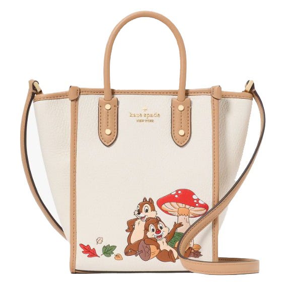 A Kate Spade New York handbag featuring a playful design with two cartoon chipmunks and a red mushroom, accented with brown handles and a crossbody strap.