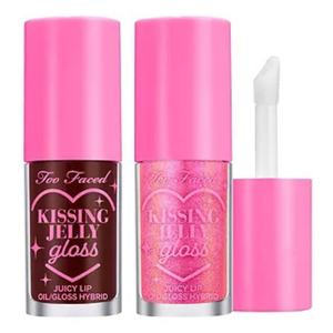 A 2-piece set of Too Faced Kissing Jelly Glosses features two tubes with bright pink caps. One is a deep red-brown shade, and the other is a shimmering pink. Both are labeled as \“Juicy Lip Oil/Gloss Hybrid.\“