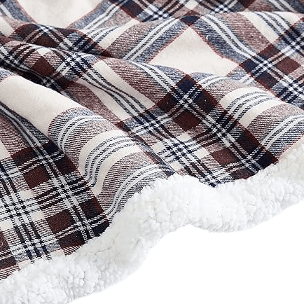 A cozy blanket featuring a classic plaid pattern with brown, blue, and white tones, lined with soft white sherpa for added warmth and comfort.