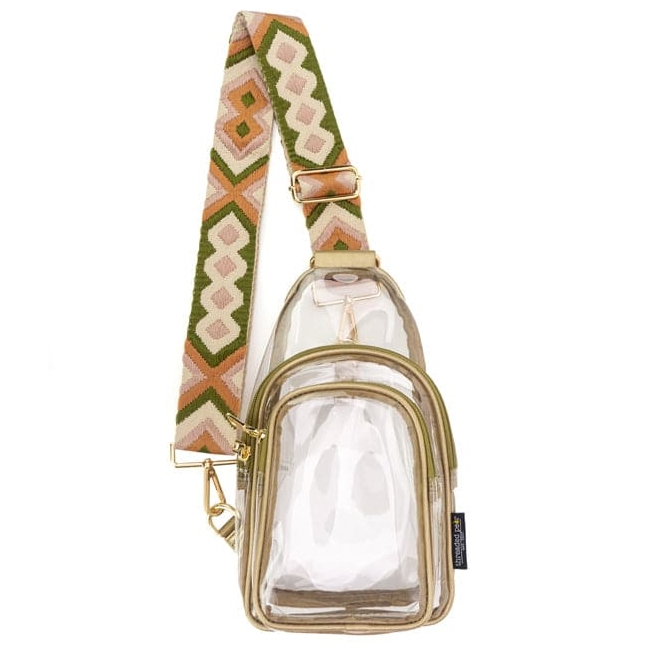 Clear sling bag with gold zippers and a multicolored strap featuring geometric patterns in green, pink, and orange. The bag has two compartments, allowing visibility of contents, and gold-tone hardware.