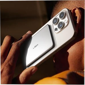 A person holds a smartphone with three rear cameras, featuring a silver Lisen-branded accessory attached to the back.
