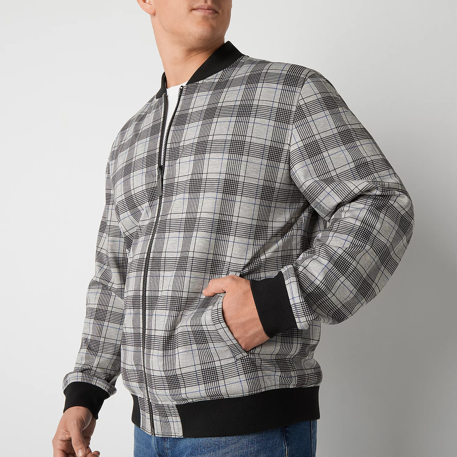 A man is wearing a plaid bomber jacket with black ribbed cuffs and collar.