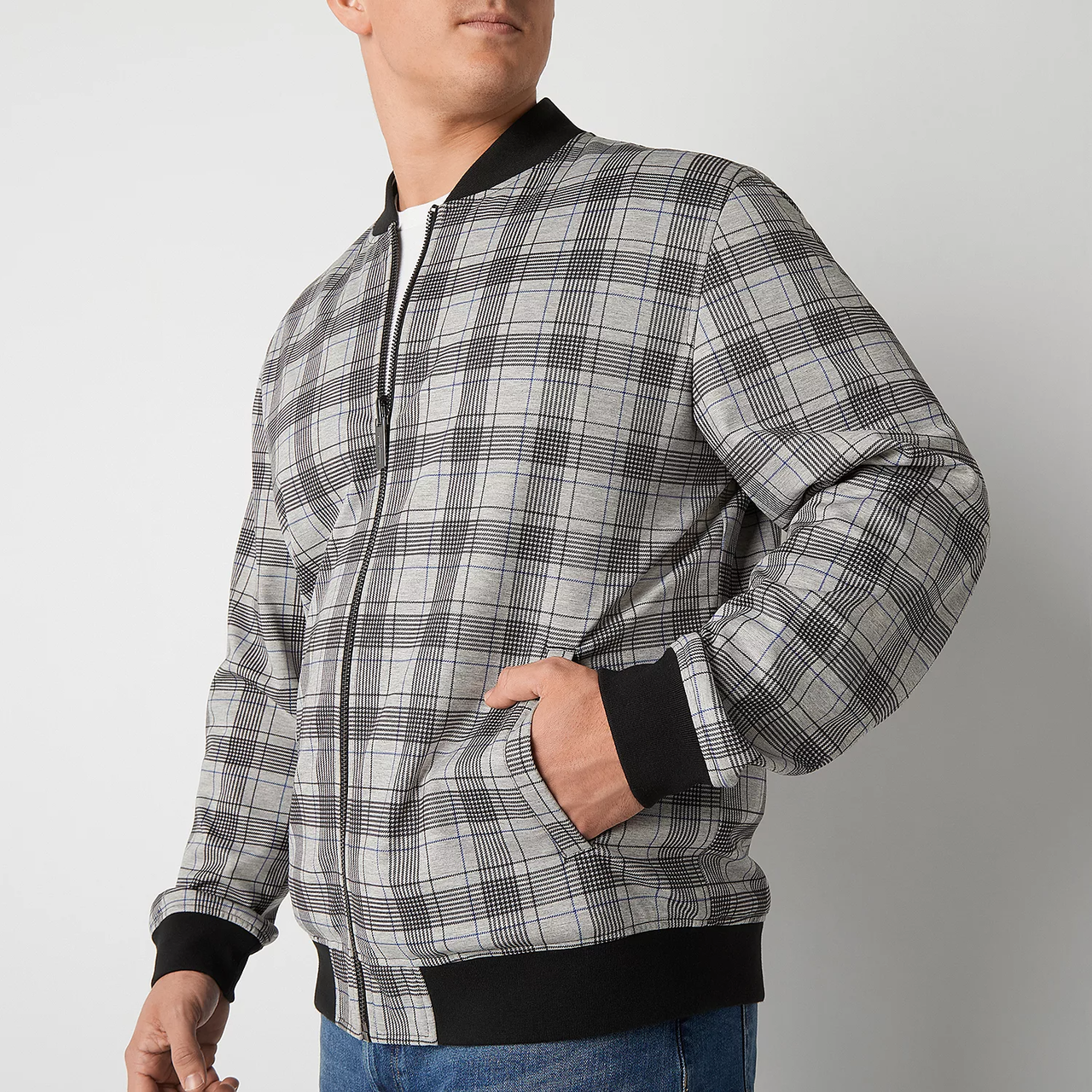A man is wearing a plaid bomber jacket with black ribbed cuffs and collar.
