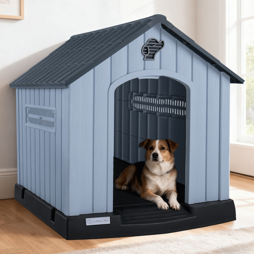 A dog is lying inside a blue plastic doghouse with a black base, featuring ventilation slats and a dog-shaped cutout for decoration.
