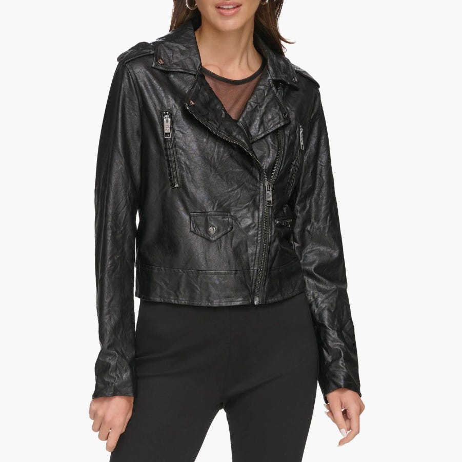 A woman is wearing a black washed faux-leather moto jacket with asymmetrical zipper closure and multiple zippered pockets.