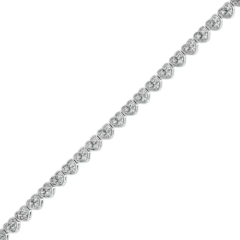 A silver bracelet featuring a series of heart-shaped settings, each containing a round-cut diamond.