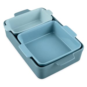 A set of three nested baking dishes in varying shades of blue, featuring rectangular and square shapes with built-in handles.