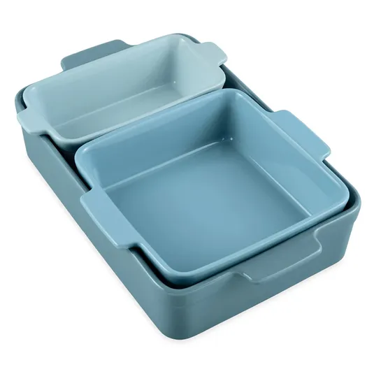 A set of three nested baking dishes in varying shades of blue, featuring rectangular and square shapes with built-in handles.