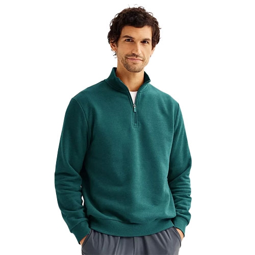 A man is wearing a teal quarter-zip sweatshirt with gray pants.