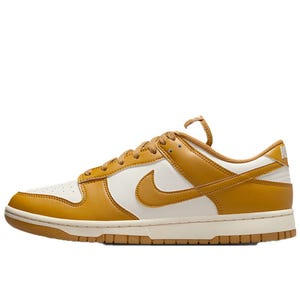 A low-top sneaker with a white base and golden-brown overlays, featuring a swoosh logo and a matching sole.