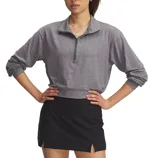 A person wearing a gray long-sleeve, half-zip pullover top and a black skirt with a side slit.